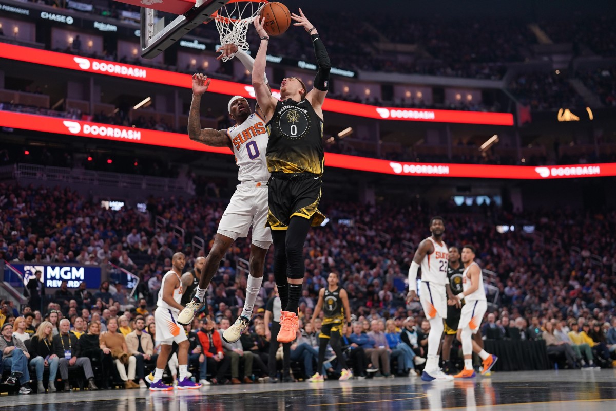 Golden State Warriors guard Donte DiVincenzo (0) loses control of the ball next to Phoenix Suns forward Torrey Craig (0)