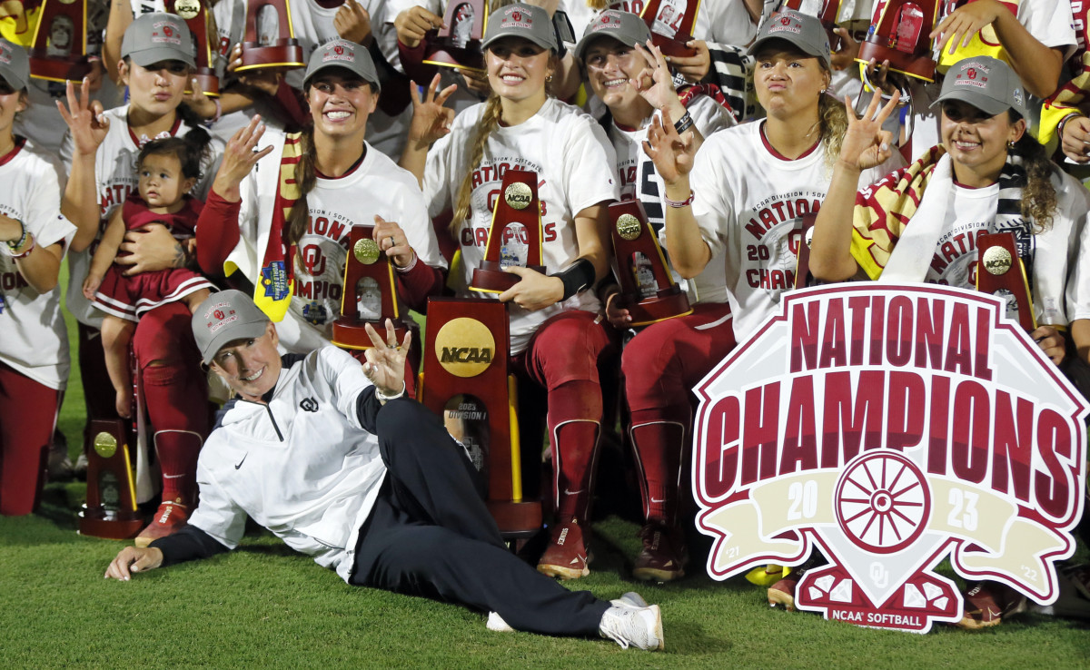 Oklahoma coach Patty Gasso players hold up three fingers after winning their third consecutive Women's College World Series title.