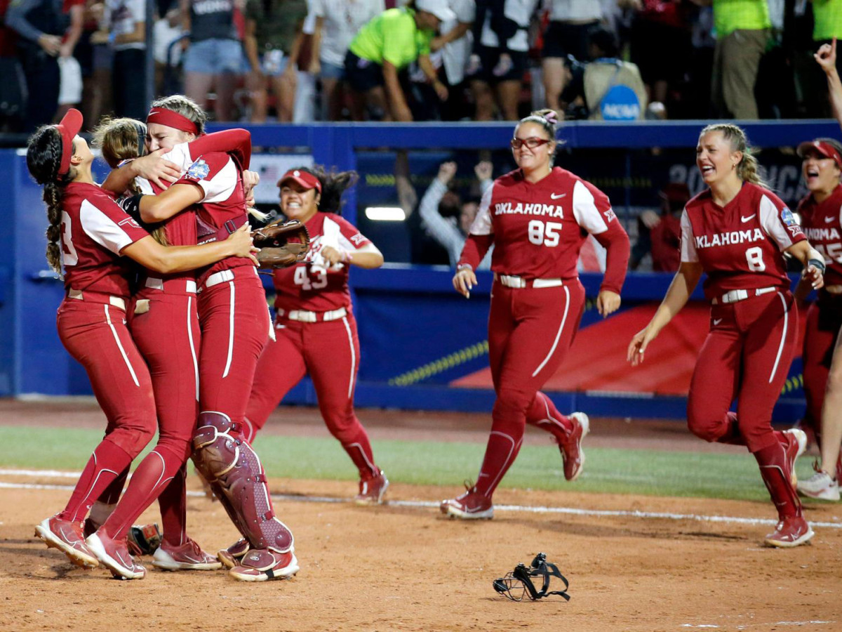 Oklahoma players gather and hug after winning the Women's College World Series.