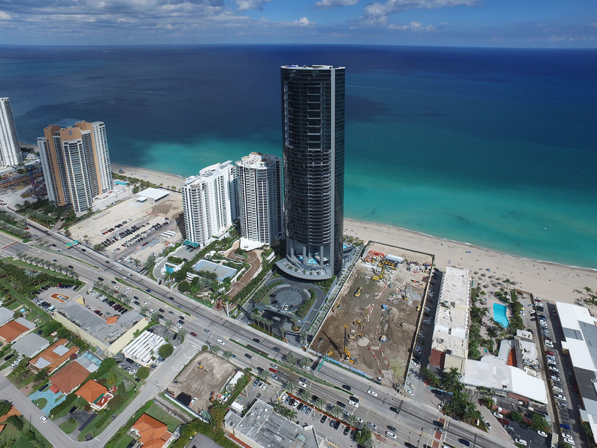 The Porsche Design Tower stands taller than the neighboring buildings