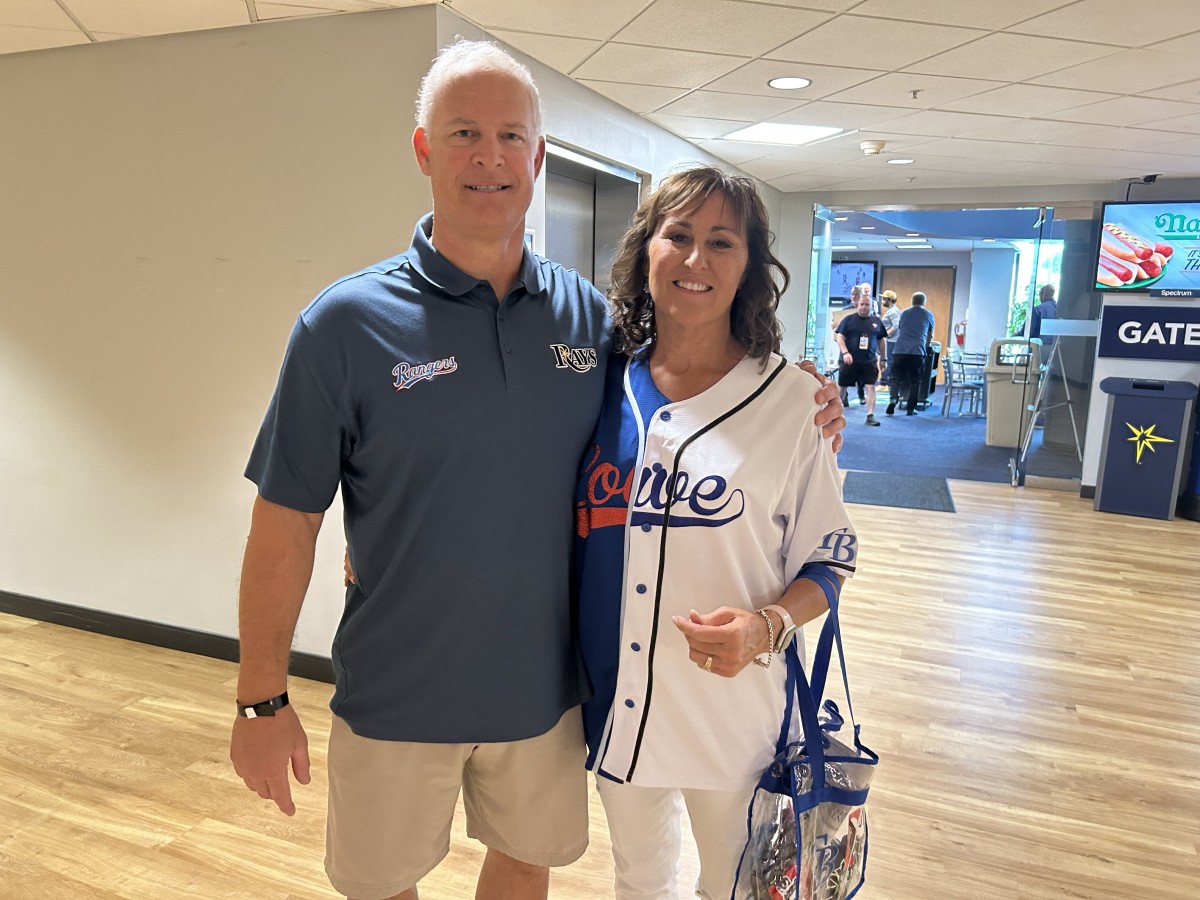 Dave and Wendy Lowe are excited to watch their two sons play baseball this weekend. They're even dressed fairly, showing no bias in representing both son and their teams. (Photo by Tom Brew)