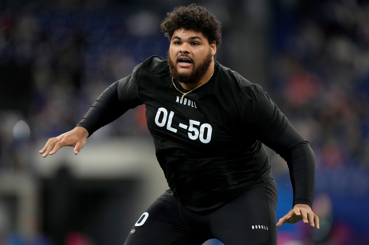 Darnell Wright puts his arms out to the side wearing a black shirt at the combine
