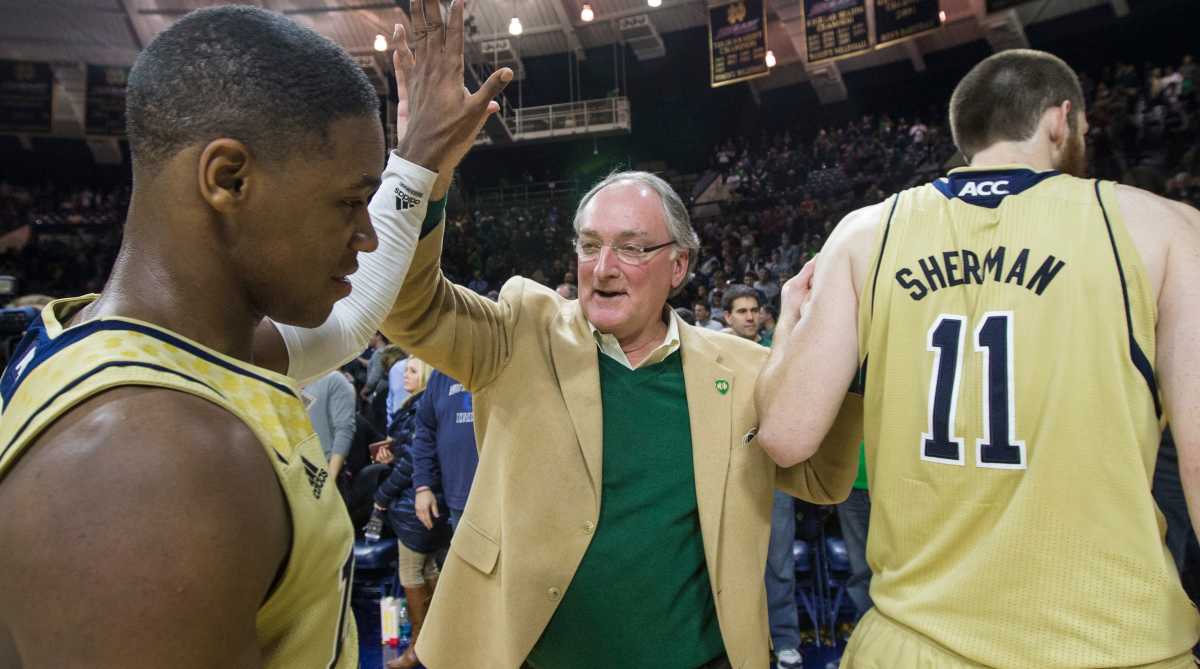 Notre Dame athletic directory Jack Swarbrick celebrates with basketball players after a win