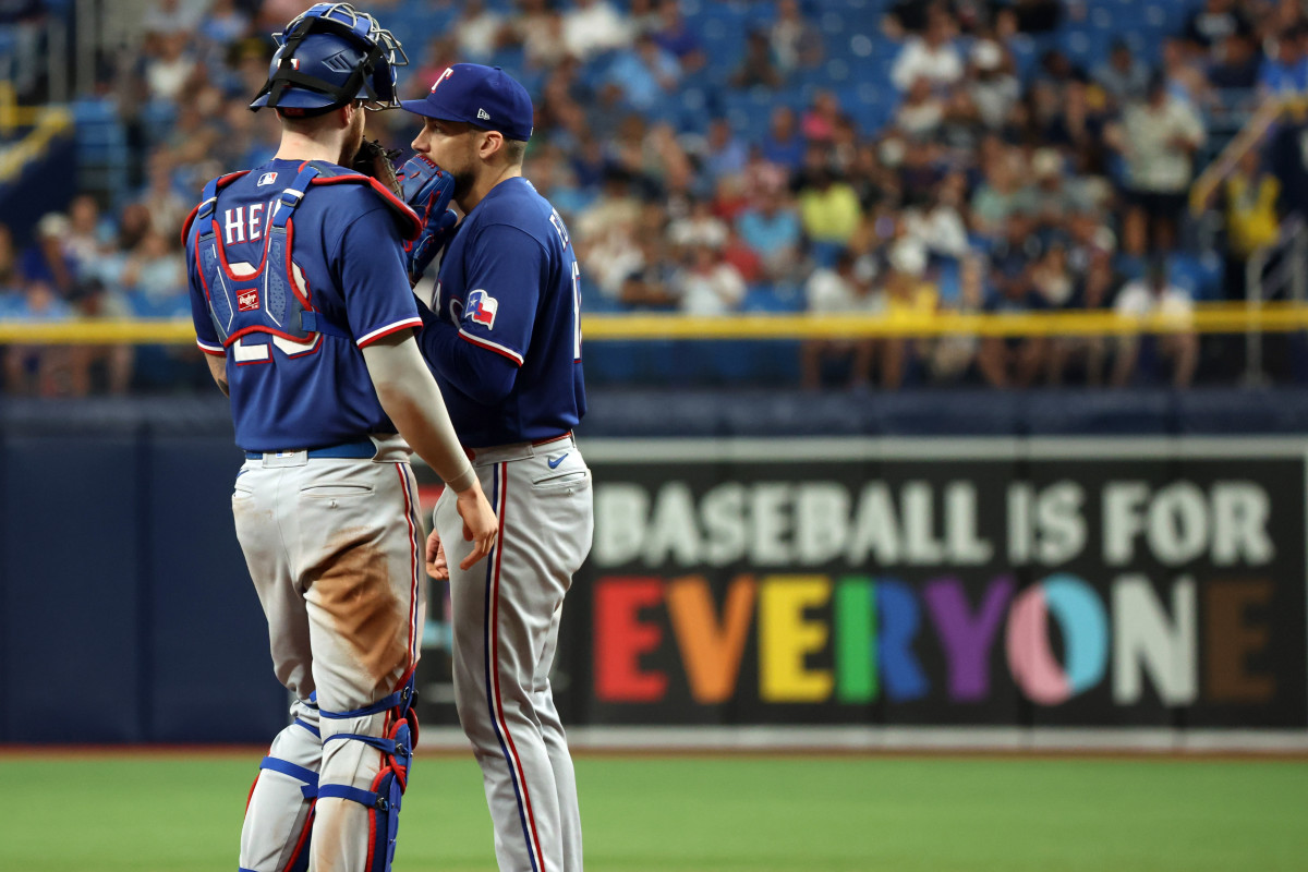 Jun 10, 2023; St. Petersburg, Florida, USA; Texas Rangers starting pitcher Nathan Eovaldi (17) talks with catcher Jonah Heim (28) at the mound during the seventh inning against the Tampa Bay Rays at Tropicana Field. Mandatory Credit: Kim Klement-USA TODAY Sports. Pride Night. Pride Month.