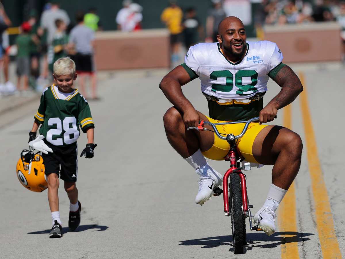 AJ Dillon rides a little kid's bike to practice in 2022. (Photo by Dan Powers/USA Today Sports)