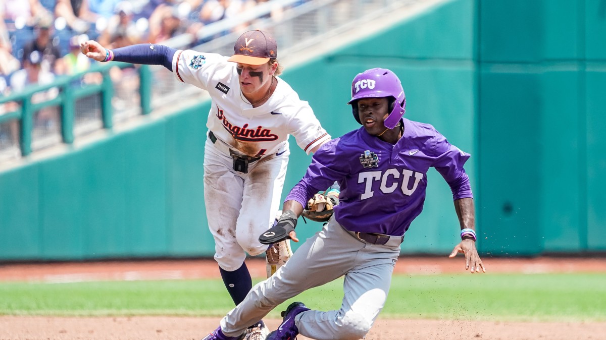 TCU Horned Frogs right fielder Austin Davis (11) is tagged out by Virginia Cavaliers shortstop Griff O'Ferrall (6) during the second inning at Charles Schwab Field Omaha.
