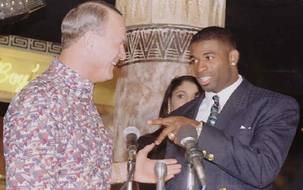 Deion Sanders (R) talks with Dallas Cowboy's head coach Barry Switzer 20 February after Sanders announced that he will play football full-time in 1996. Sanders spoke during a news conference at his nightclub "Primetime 21" in Dallas