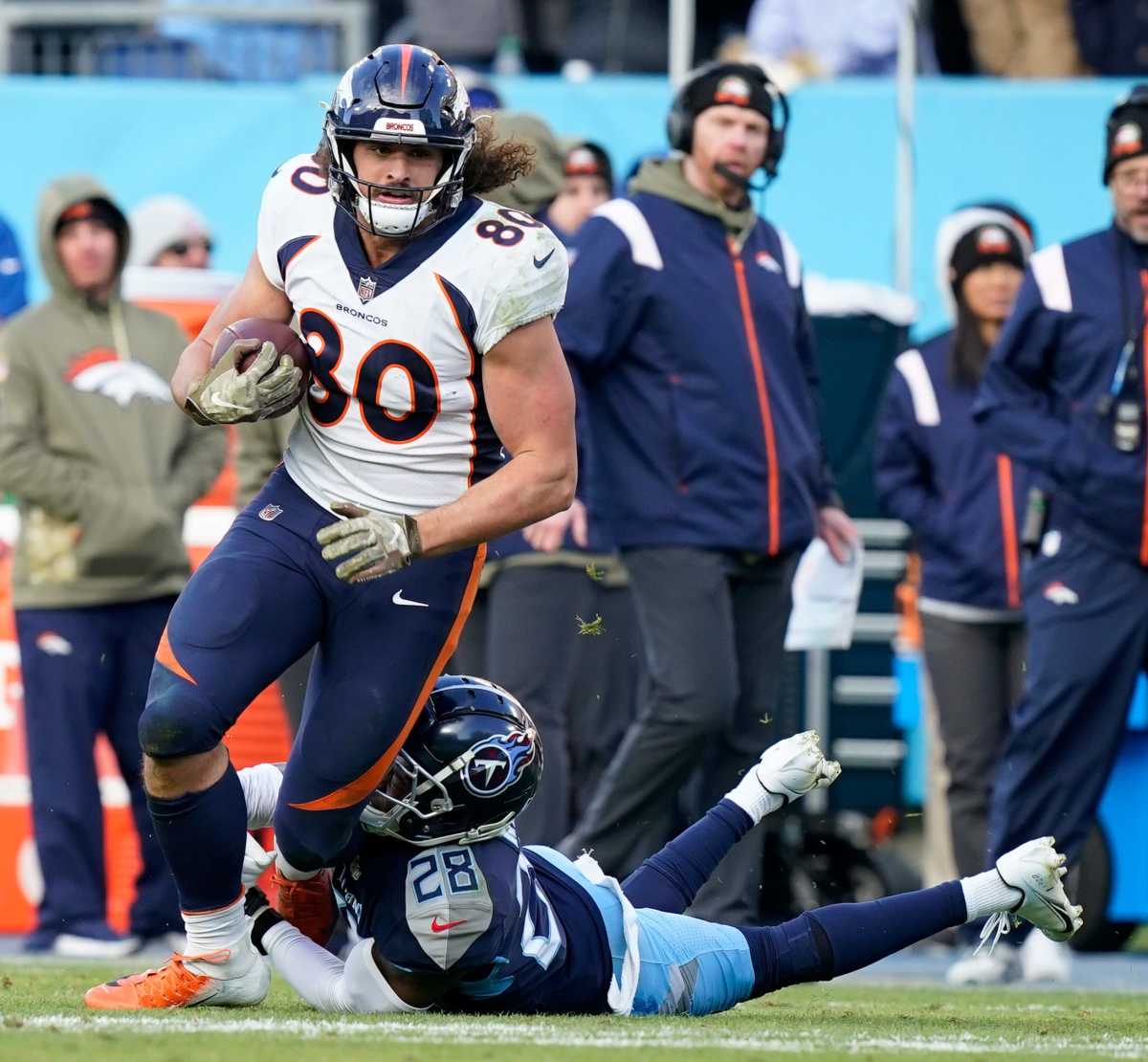 Denver Broncos tight end Greg Dulcich runs with the ball and is tackled by a Tennessee Titans defender