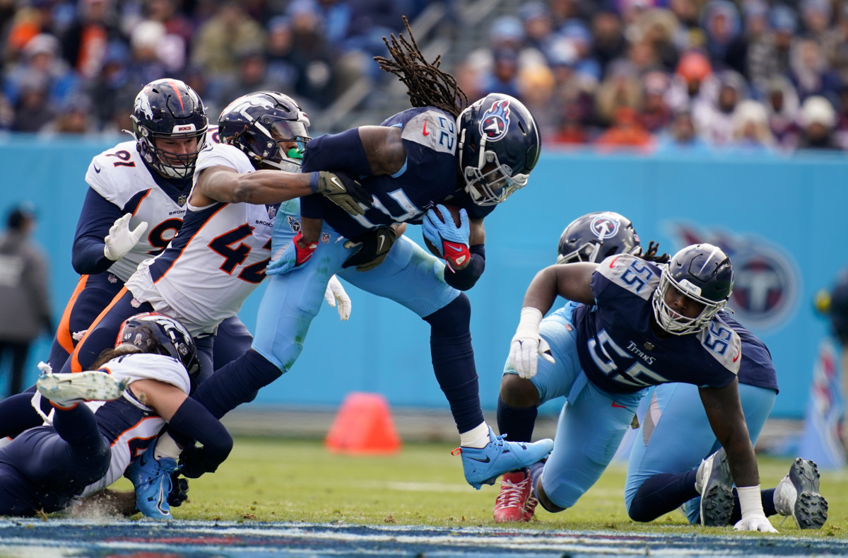 Derrick Henry holds the ball as he is is tackled by Denver Broncos linebacker Nik Bonitto