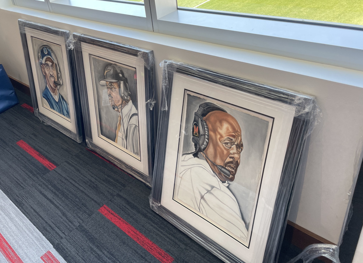 pictures of Black coaches sit on the floor waiting to hung