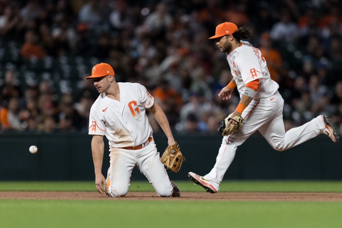 SF Giants third baseman Kevin Padlo and shortstop Brandon Crawford struggle for possession during the eighth inning against the New York Mets at Oracle Park. (2022)