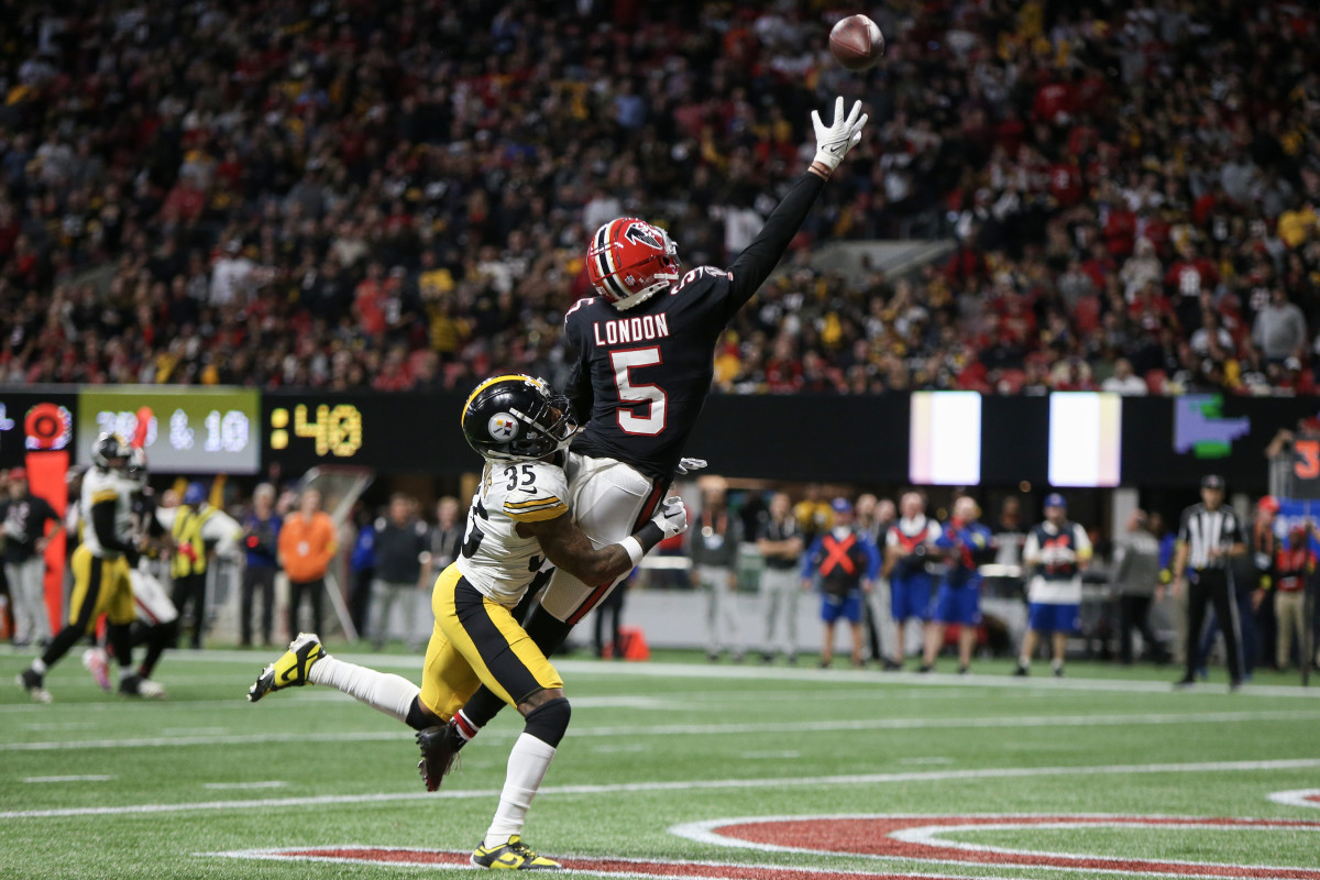 Pittsburgh Steelers cornerback Arthur Maulet  wraps his arms around Atlanta Falcons wide receiver Drake London’s legs as he jumps up to catch a pass