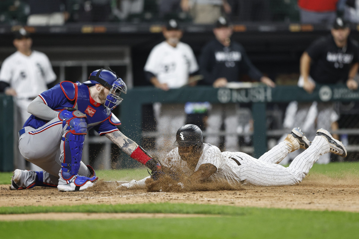 Jun 20, 2023; Chicago, Illinois, USA; Chicago White Sox shortstop Elvis Andrus (1) scores against Texas Rangers catcher Jonah Heim (28) during the eighth inning at Guaranteed Rate Field. Mandatory Credit: Kamil Krzaczynski-USA TODAY Sports