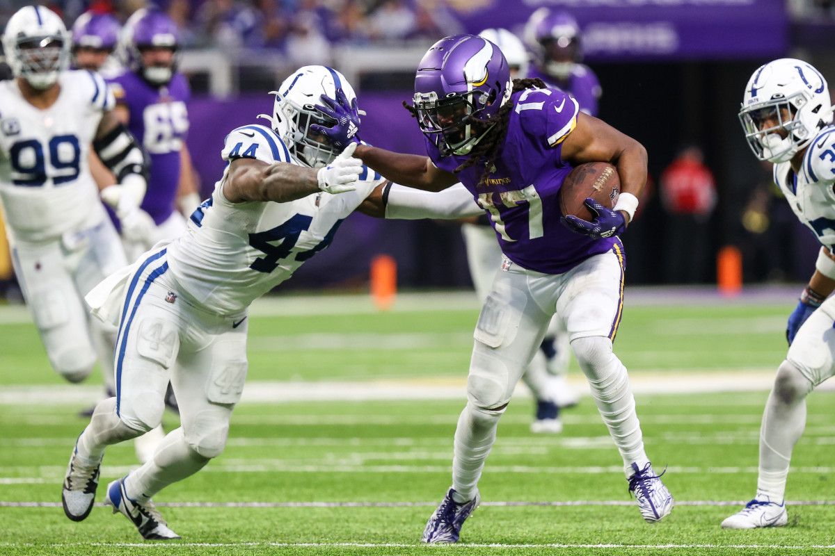 Vikings receiver K.J. Osborn stiff-arms a player on the Colts after a catch.