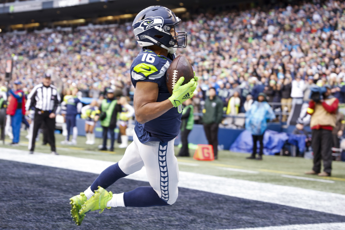 Tyler Lockett is in the air with the ball in his hands