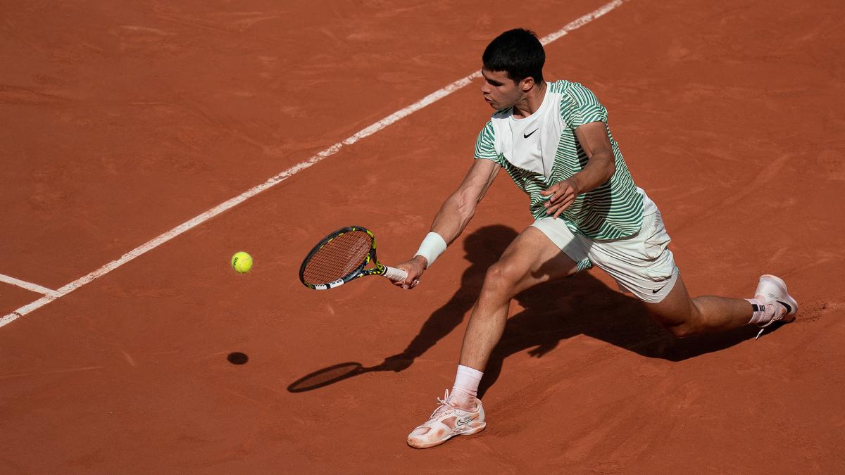 Carlos Alcaraz returns a shot against Novak Djokovic