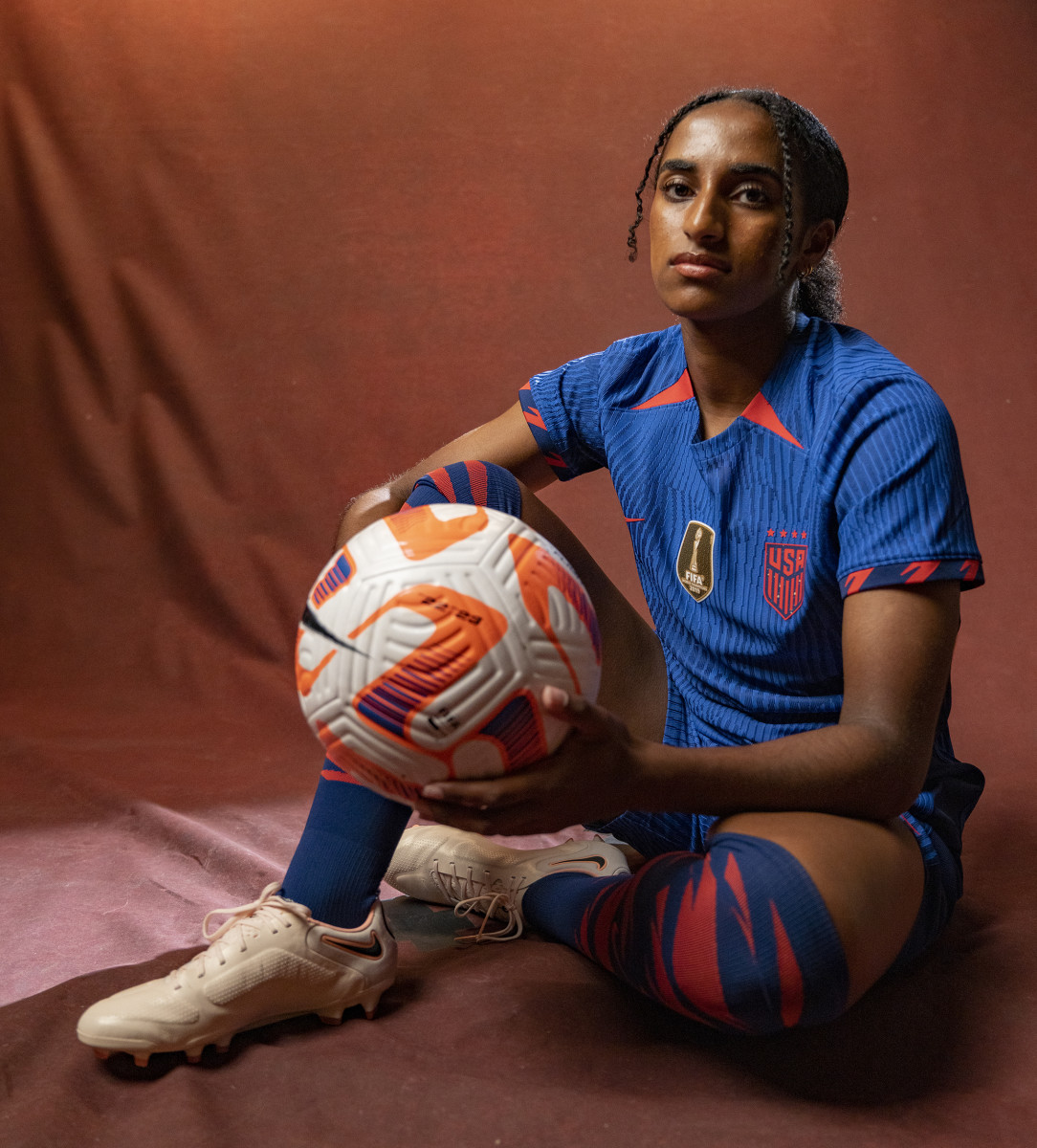 U.S. women's national team defender Naoimi Girma poses with a soccer ball.
