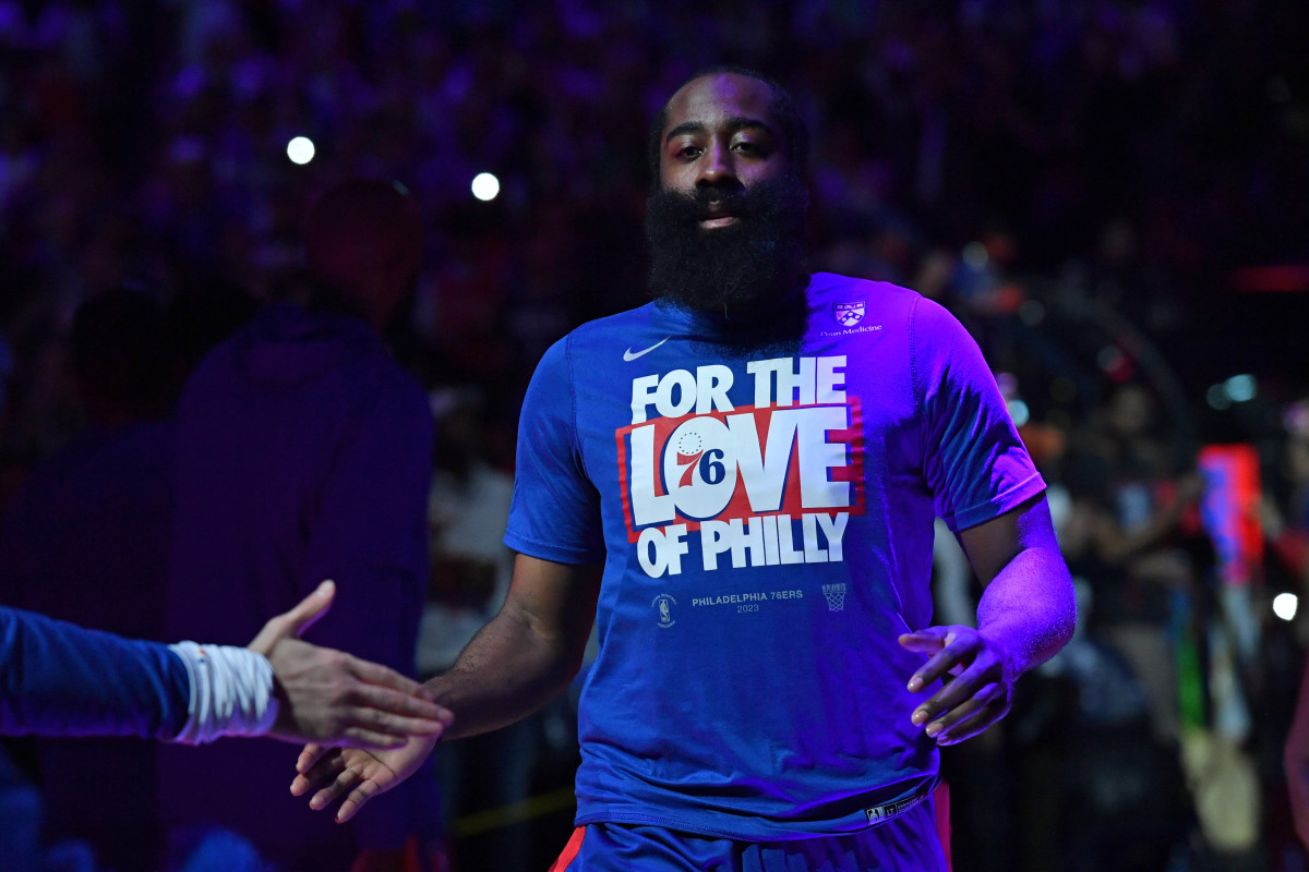 James Harden jogs onto the court giving someone a high five and wearing a shirt that says “For the Love of Philly”