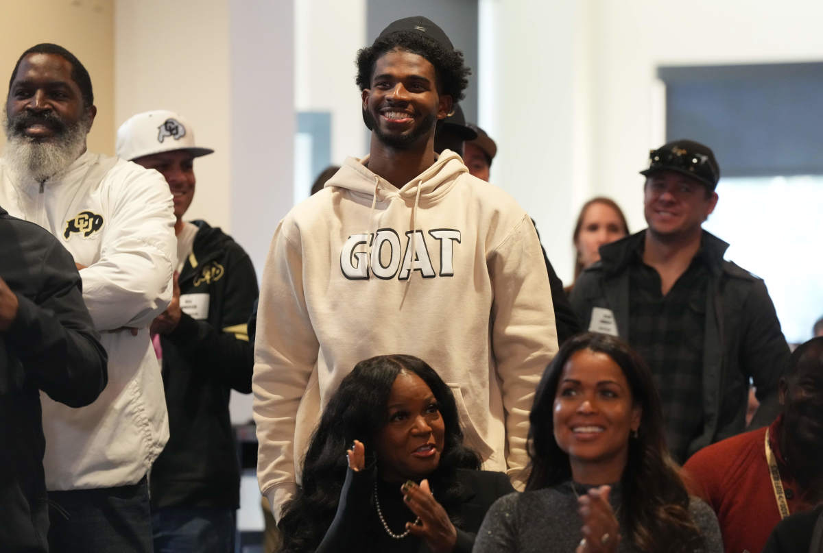 Jackson State quarterback Shedeur Sanders stands smiling in a GOAT sweatshirt