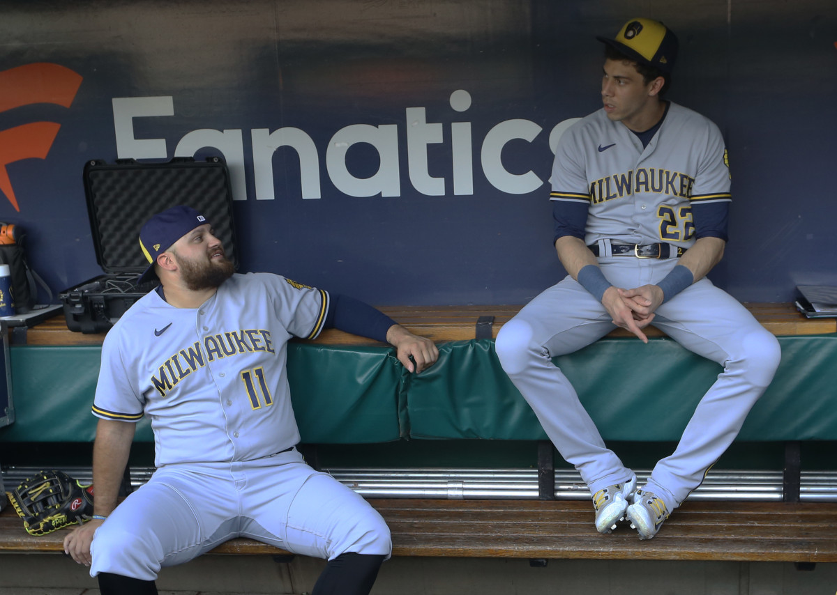 Brewers teammates Rowdy Tellez and Christian Yelich talk in the dugout