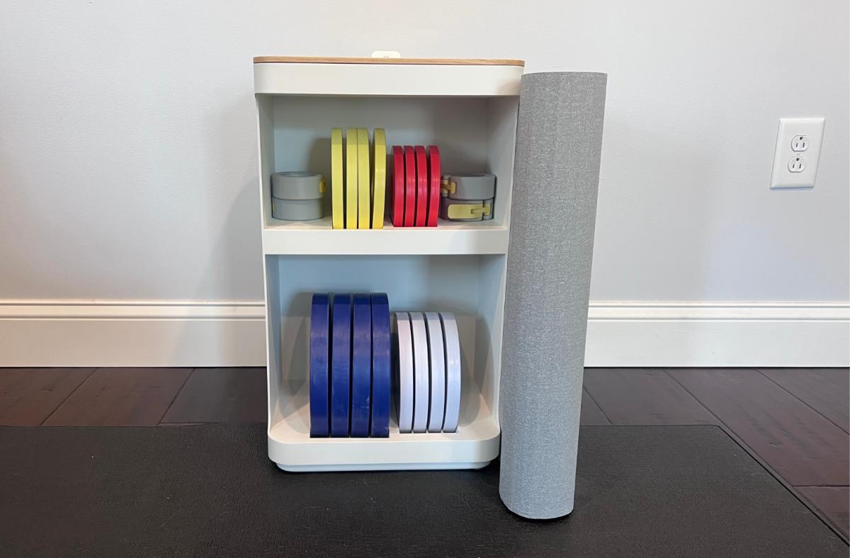 The Tempo Move collection, including a storage shelf, weight plates, a barbell and hand weights.