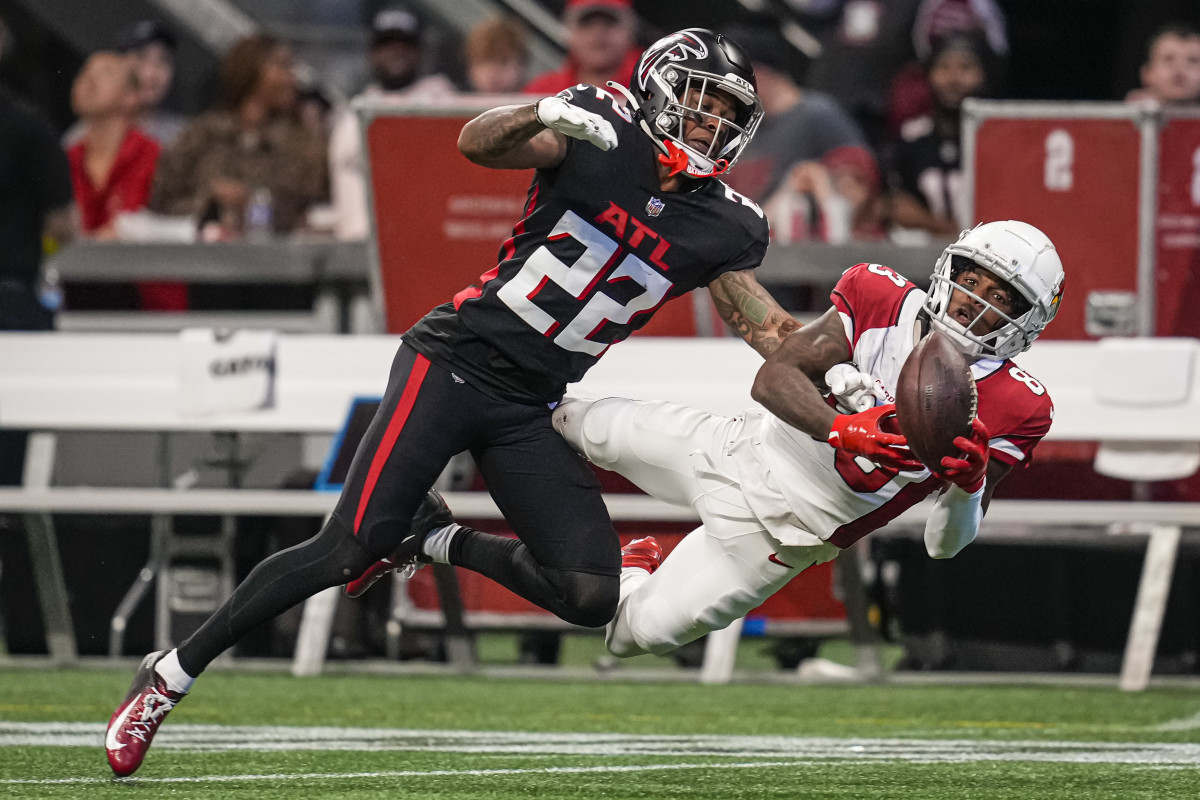 Arizona Cardinals wide receiver Greg Dortch falls sideway as he jumps to catch the ball, while a Falcons defender tries to reach his hand for it