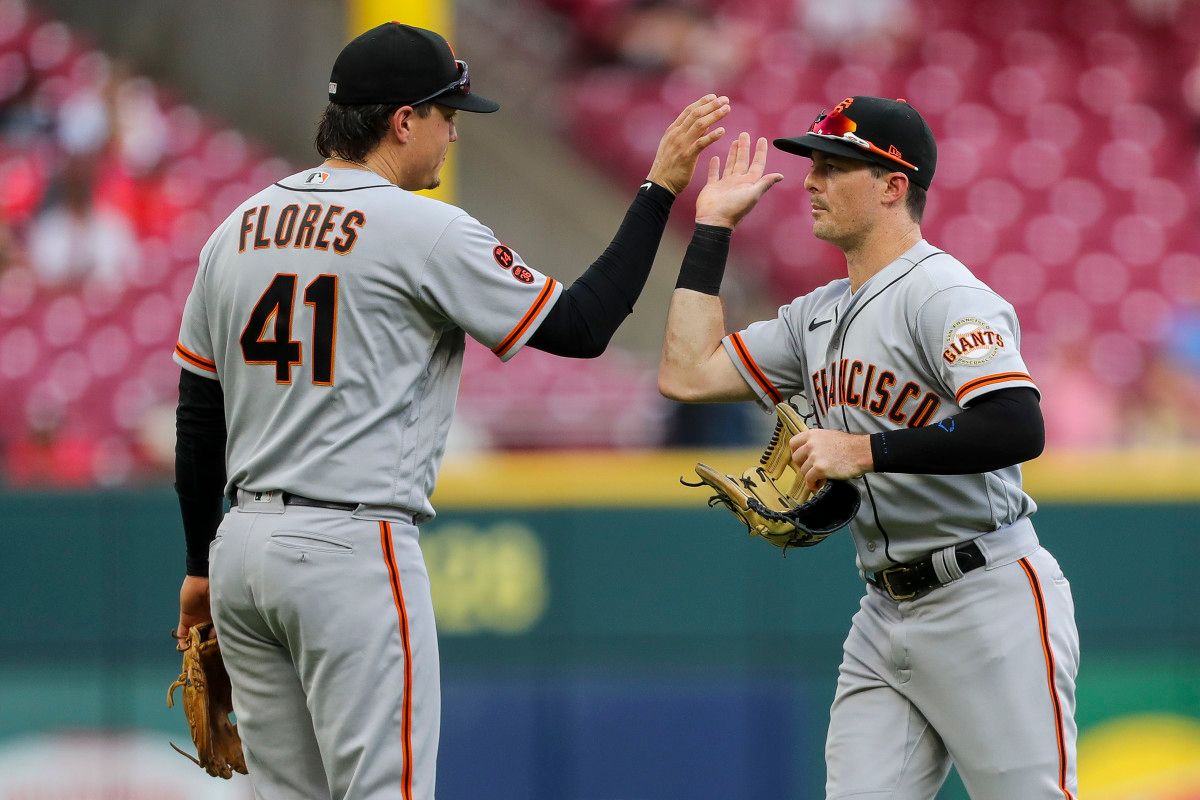 SF Giants third baseman Wilmer Flores (41) high fives right fielder Mike Yastrzemski (5) after a win at Great American Ball Park (2023)