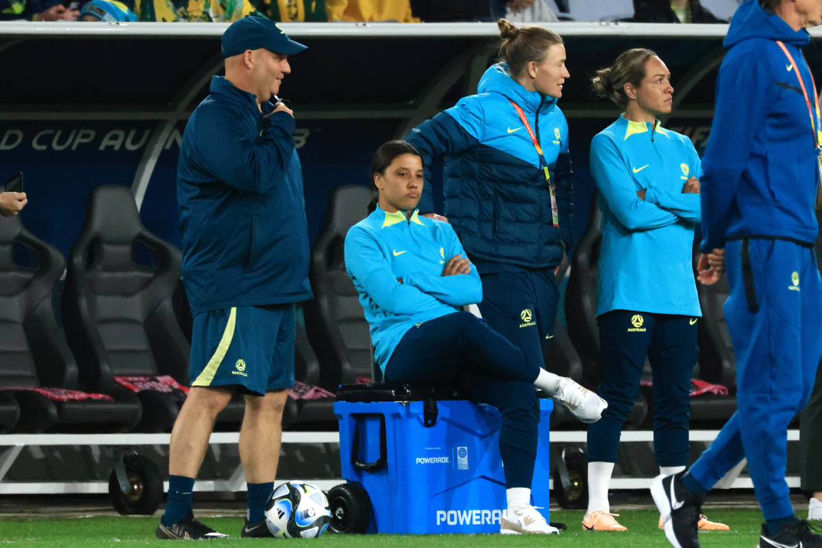 Sam Kerr pictured sitting on a cooler box by the side of the field during Australia's game against Ireland at the 2023 FIFA Women's World Cup