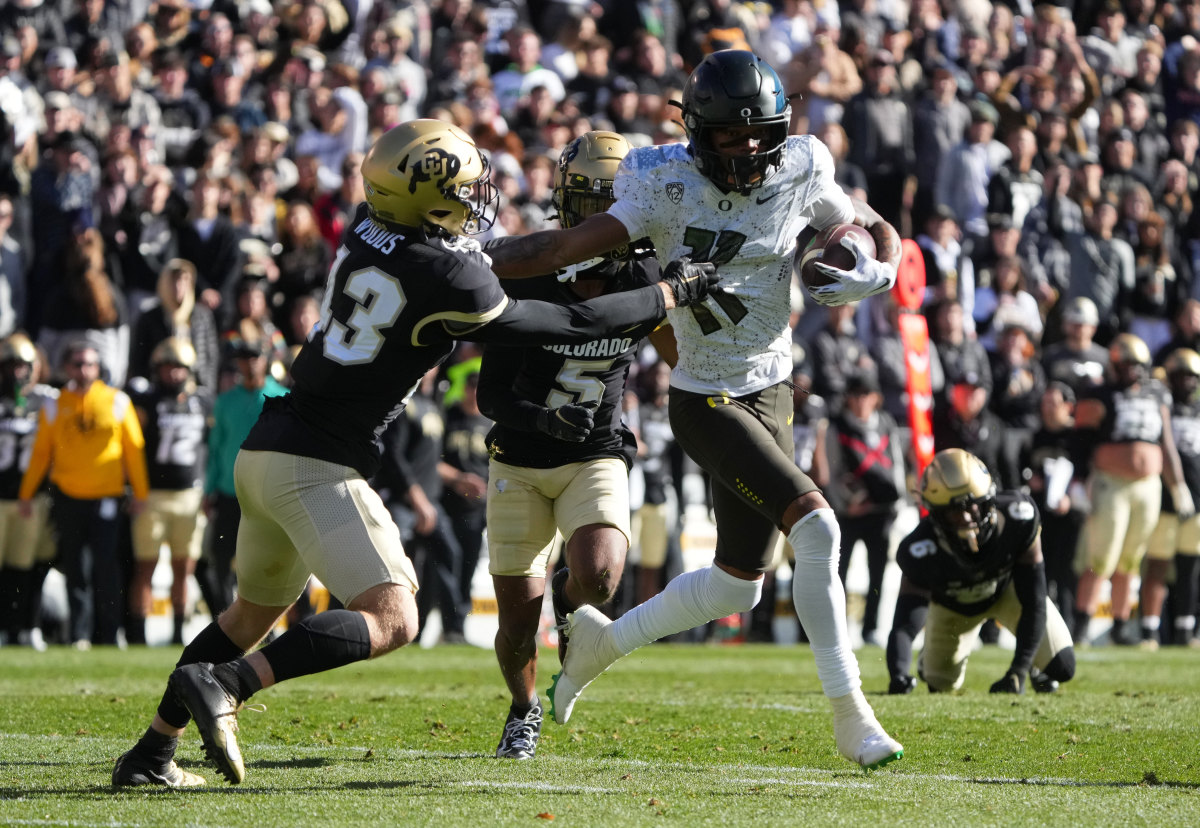 Oregon Ducks wide receiver Troy Franklin (11) pushes at Colorado Buffaloes safety Trevor Woods (43) in the first quarter at Folsom Field.