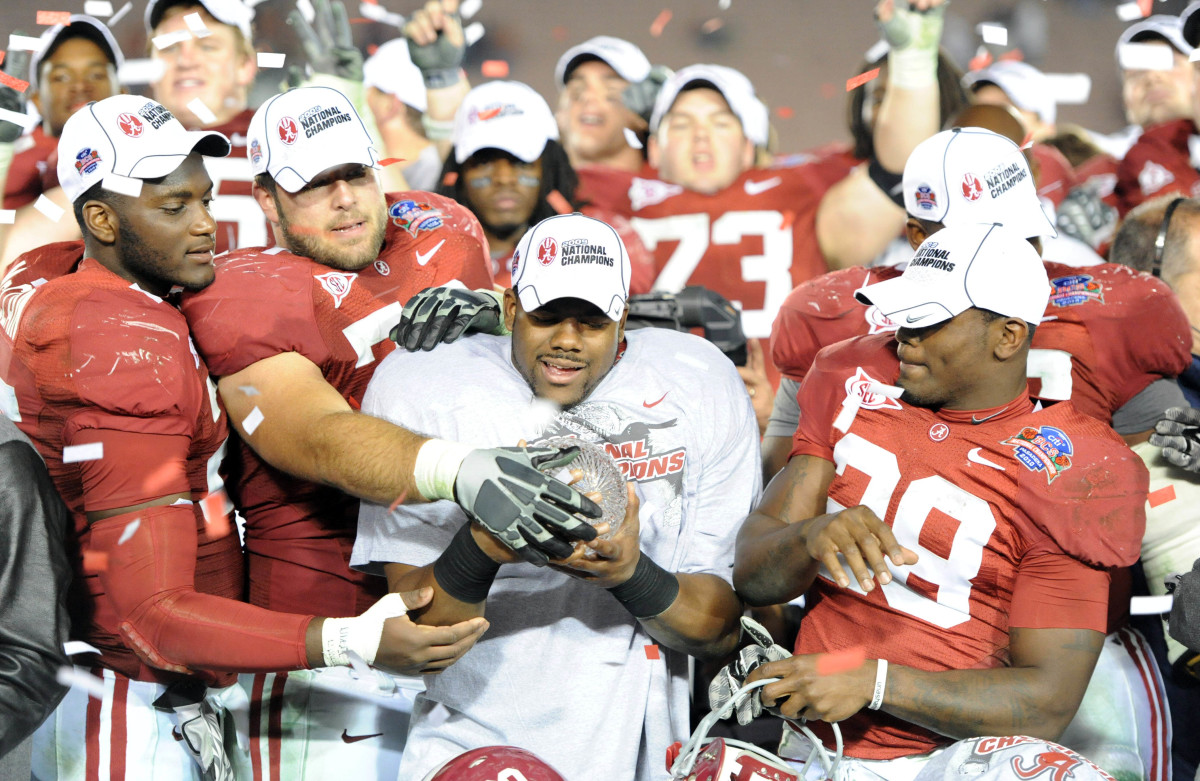 Alabama Crimson Tide running back Mark Ingram (center) is presented with the Coaches Trophy by teammates as they celebrate defeating the Texas Longhorns 37-21 in the 2010 BCS national championship game at the Rose Bowl.