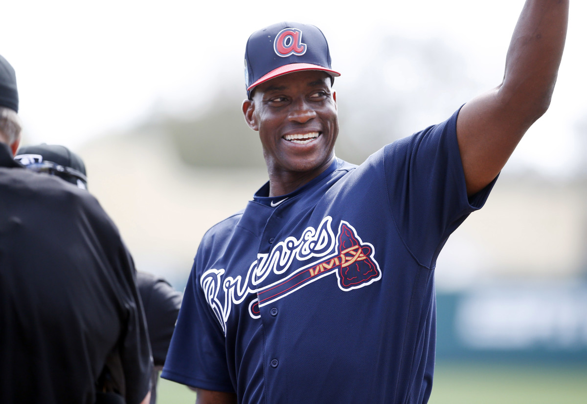 Fred McGriff puts his hands up to wave wearing a Braves jersey