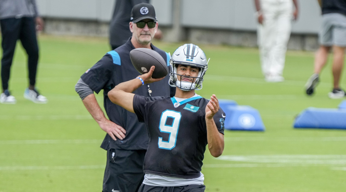 Bryce Young throws the quarterback while Frank Reich stands behind him and watches