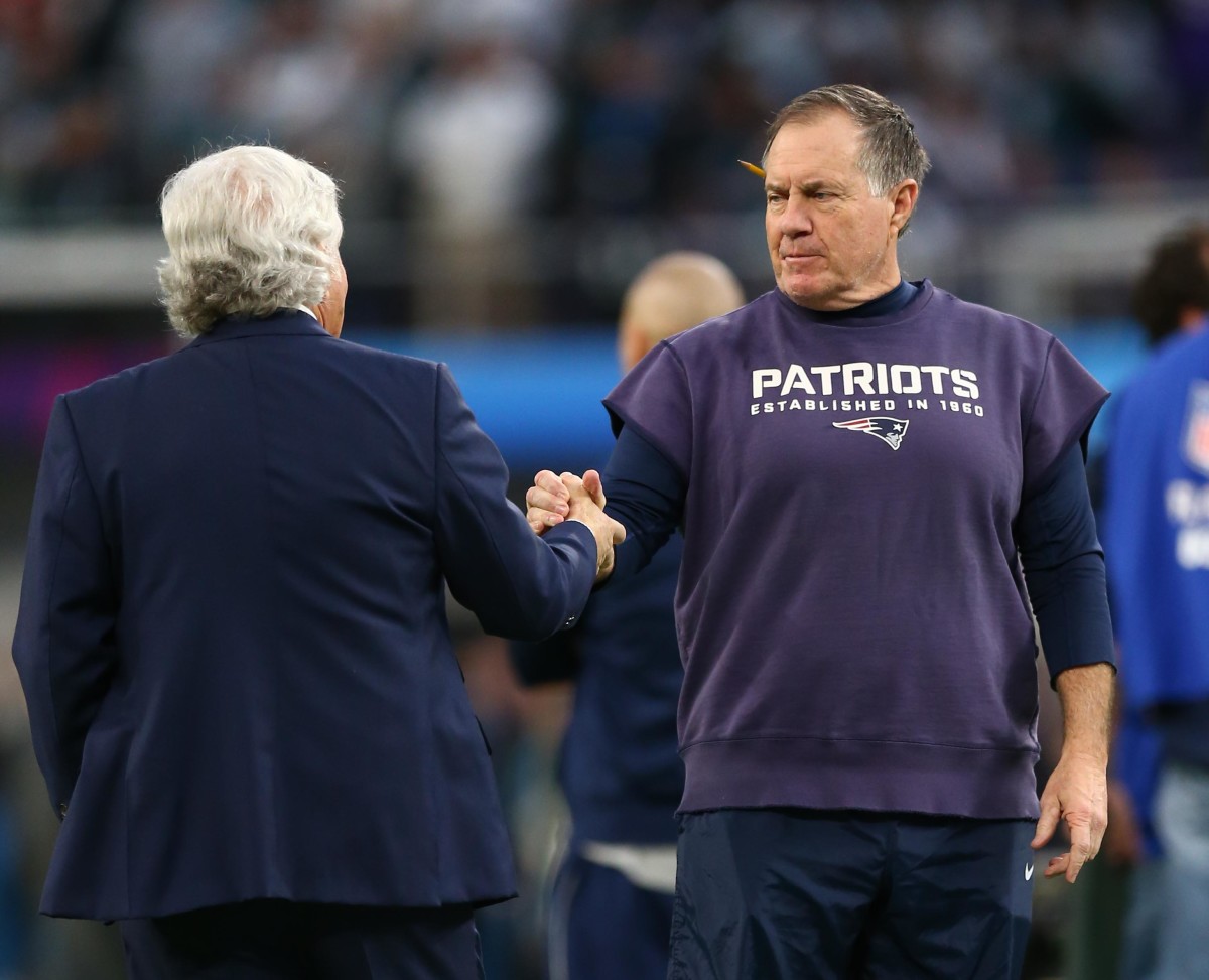 Bill Belichick grasps the hands of Robert Kraft