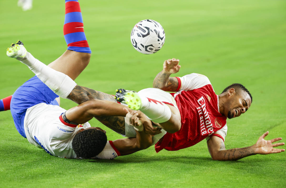 Barcelona defender Ronald Araujo (left) and Arsenal forward Gabriel Jesus (right) both pictured on the ground after competing for the ball during a pre-season friendly in July 2023