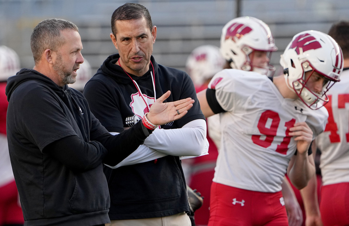 Wisconsin defensive coordinator Mike Tressel talks with head coach Luke Fickell during practice at Camp Randall Stadium.