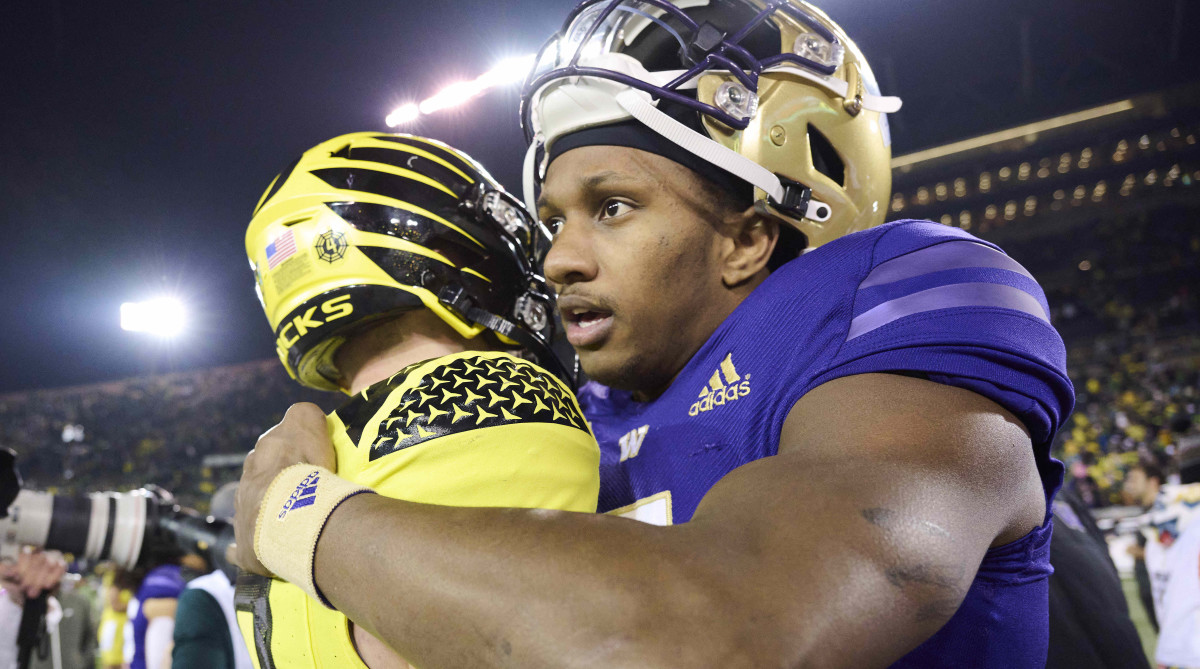 Washington Huskies quarterback Michael Penix Jr. embraces Oregon Ducks quarterback Bo Nix.