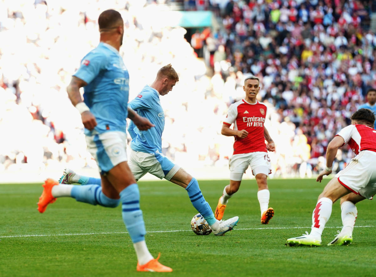 Cole Palmer pictured (center) shooting to score a goal for Manchester City against Arsenal in the 2023 FA Community Shield game at Wembley Stadium