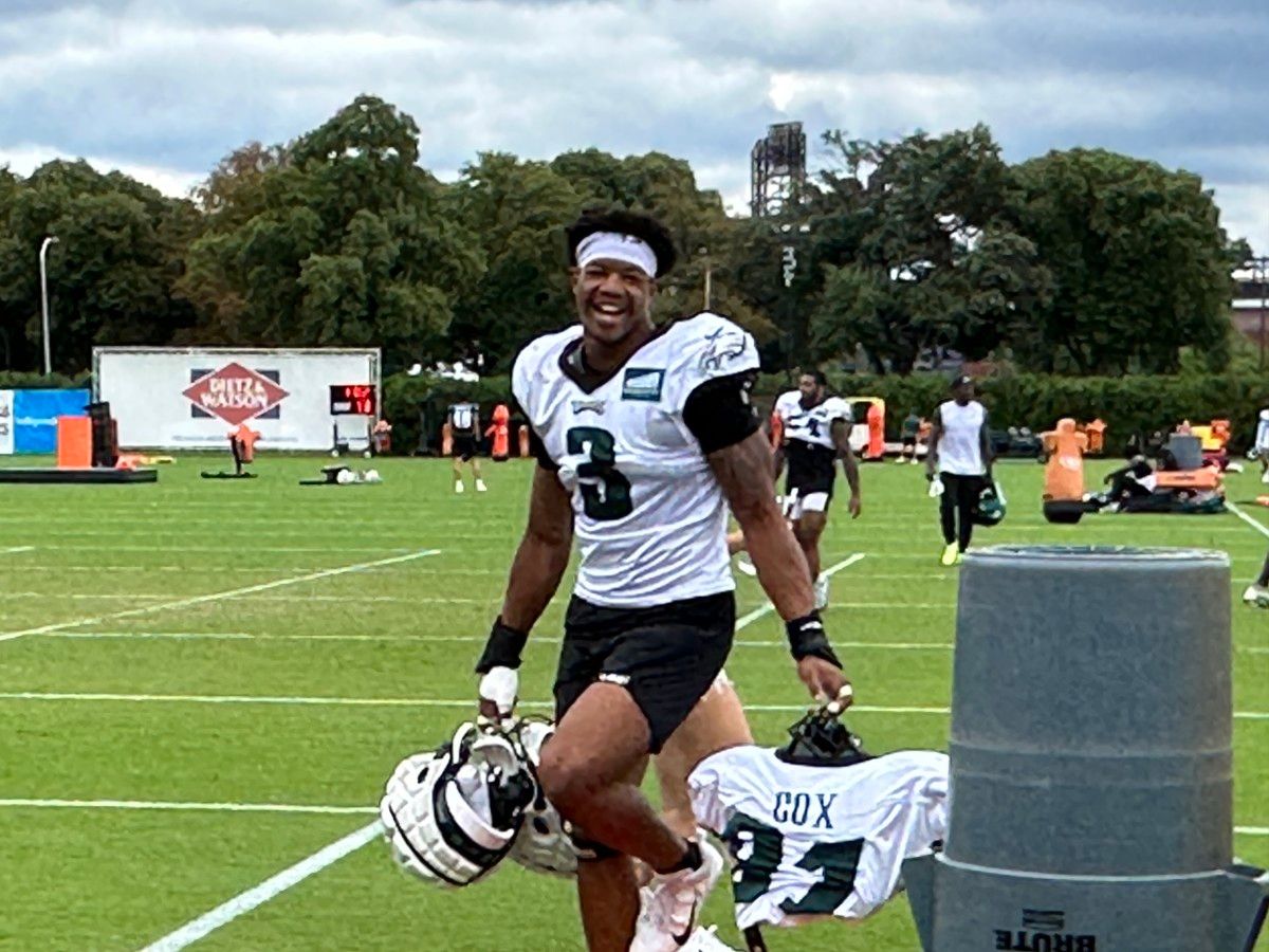 Nolan Smith carries Fletcher Cox's pads following a training camp practice