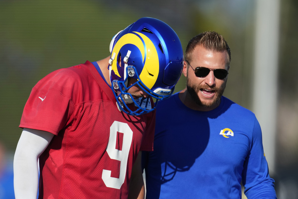 Matthew Stafford leans down with his helmet on to talk to Sean McVay
