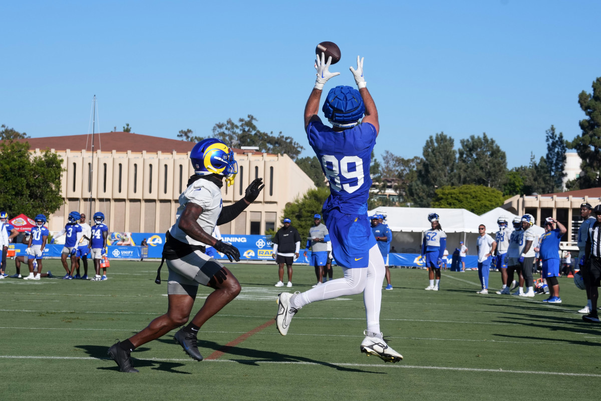 tight end Tyler Higbee jumps to catch the ball as defensive back Russ Yeast trails behind him