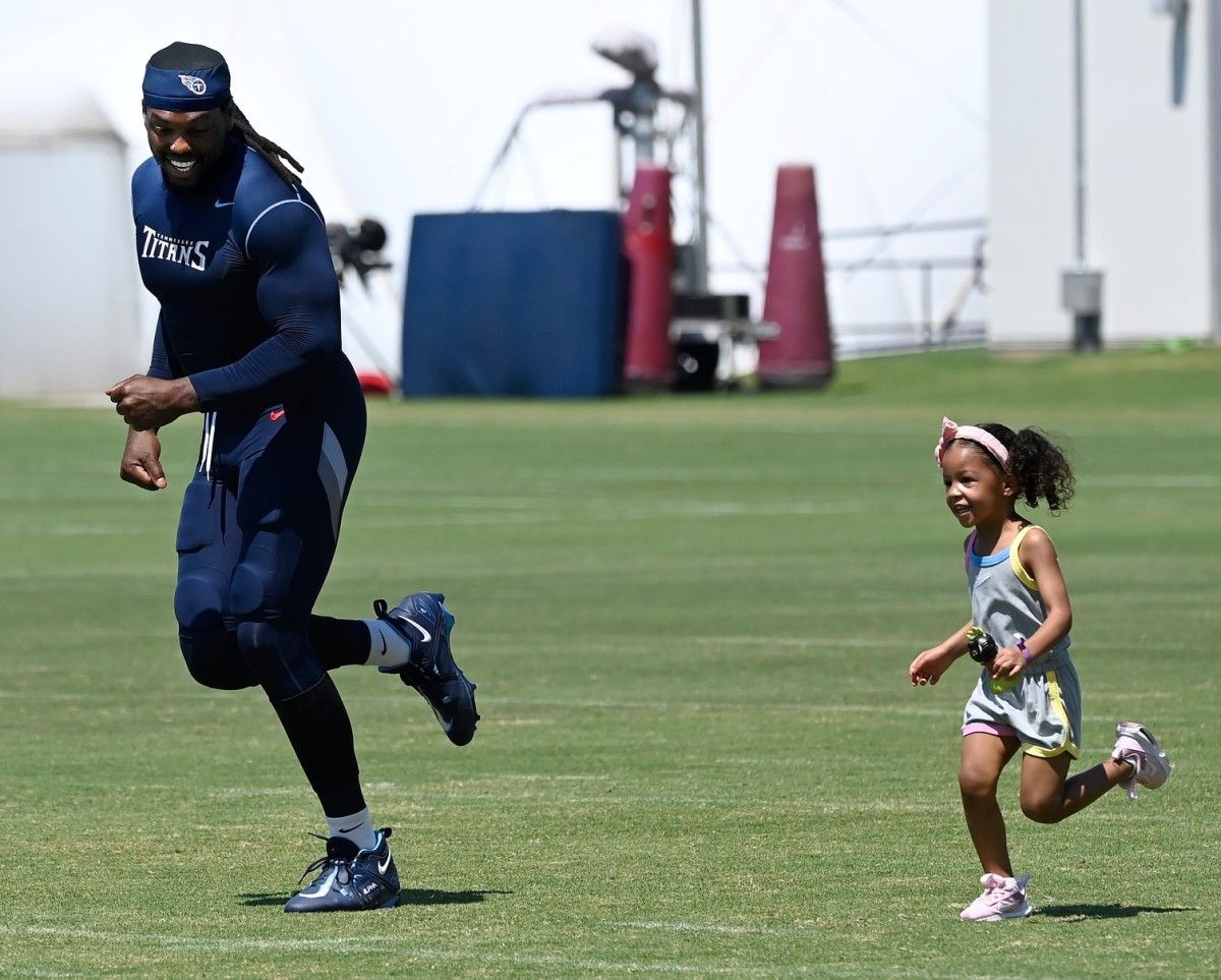 Titans running back Derrick Henry (22) runs with his daughter Valentina on the field after practice on July 31 in Nashville. (Mark Zaleski/USA TODAY Sports)