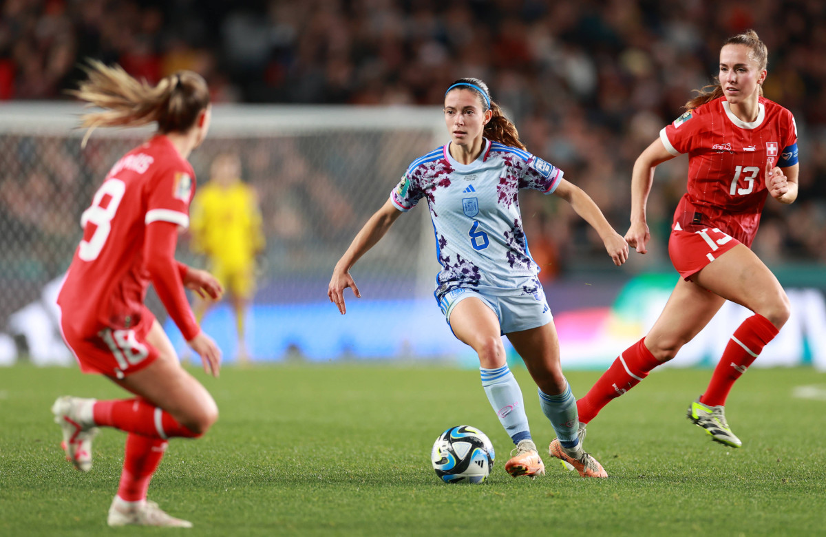 Spain's Aitana Bonmati maintains control of the ball between two Switzerland players during the round of 16 at the Women's World Cup.