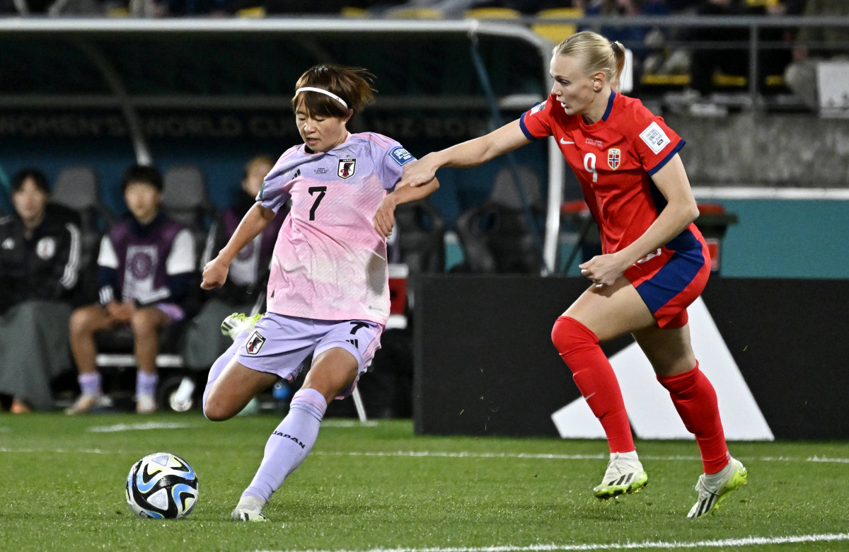 Japan's Hinata Miyazawa kicks the bowl with Karina Saevik of Norway defending her during the round of 16 at the Women's World Cup.