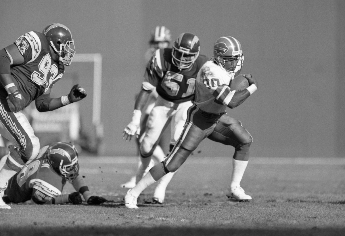 Buffalo Bills running back Joe Cribbs (20) is chased by San Diego Chargers defensive tackle Earl Wilson (93) and Woodrow Lowe (51) at Jack Murphy Stadium in 1985.