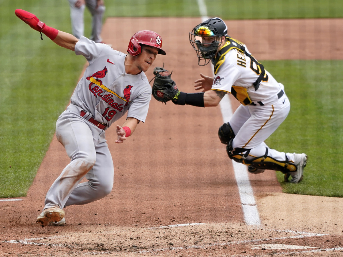 St. Louis Cardinals’ Tommy Edman (19) gets past Pittsburgh Pirates catcher Tyler Heineman to score on a sacrifice fly to right field by Nolan Arenado during the second inning of a baseball game in Pittsburgh, Sunday, May 22, 2022.