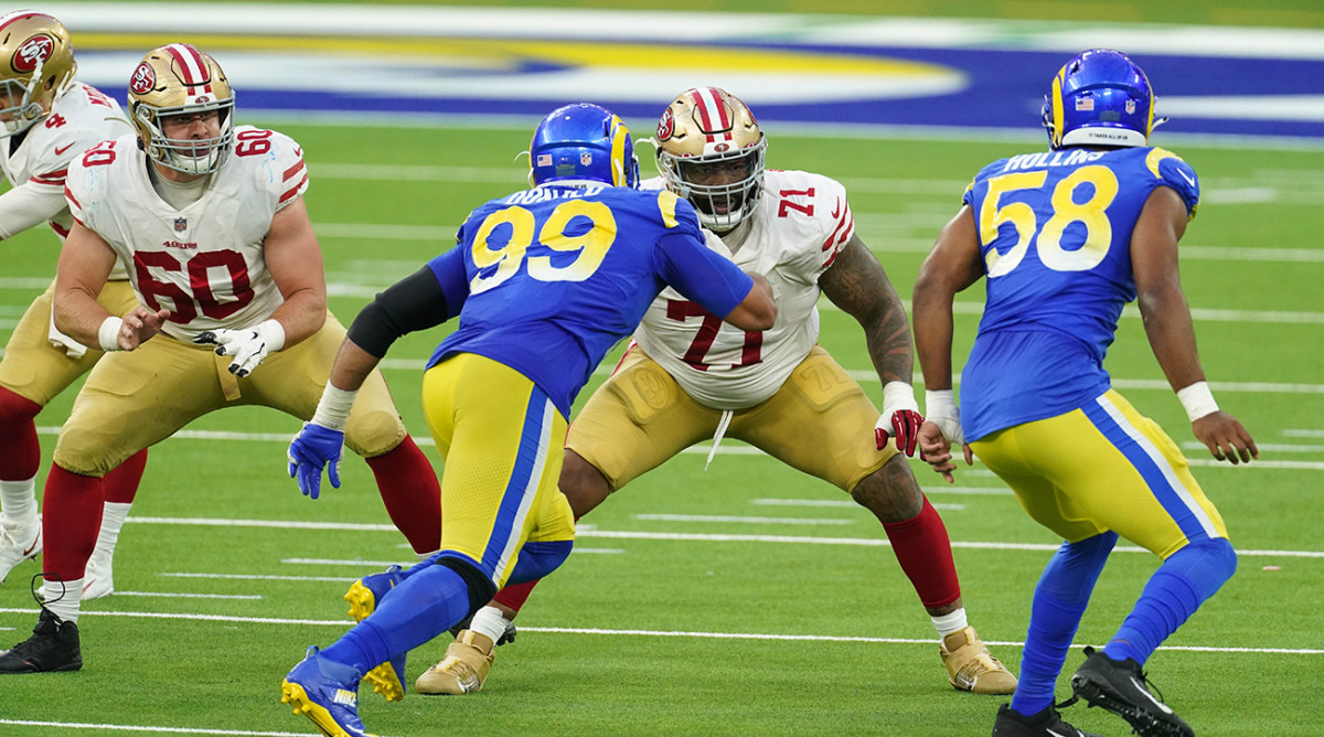 49ers offensive tackle Trent Williams (71) and offensive guard Daniel Brunskill (60) defend against Rams defensive tackle Aaron Donald (99) and linebacker Justin Hollins (58).