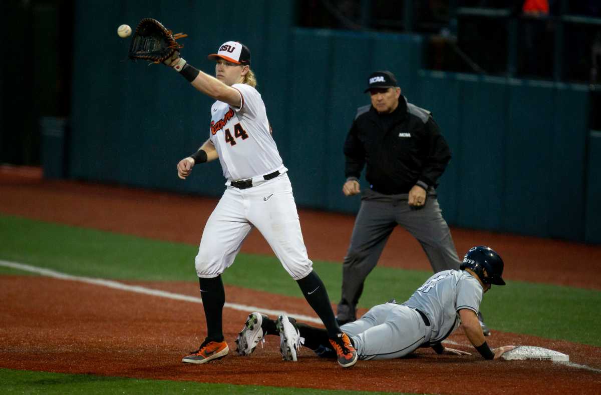 Oregon State first baseman Garret Forrester, left, makes a catch as New Mexico State second baseman Edwin Martinez-Pagani slides safely back to first base during the 2022 NCAA Corvallis Regional at Goss Stadium Friday, June 3, 2022, in Corvallis, Oregon.