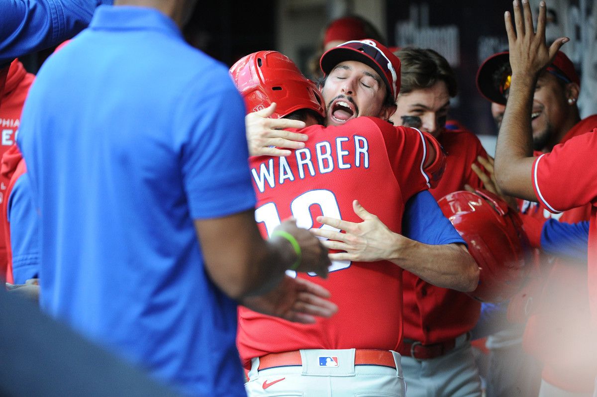 Kyle Schwarber embraces teammate Garrett Stubbs after crushing a two-run home run against the Milwaukee Brewers.