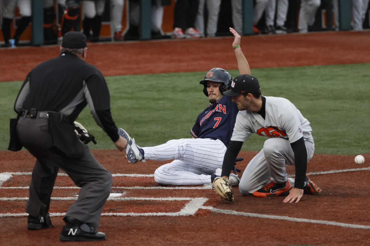 Jun 12, 2022; Corvallis, OR, USA; Auburn baseball infielder Cole Foster (7) scores a run past Oregon State Beavers pitcher Cooper Hjerpe (26) in the 4th inning during Game 2 of a NCAA Super Regional game at Coleman Field.