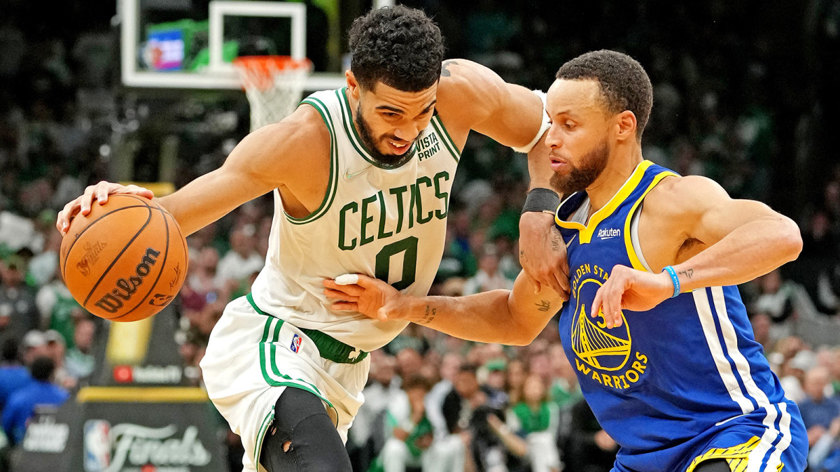 Boston Celtics forward Jayson Tatum (0) handles the ball against Golden State Warriors guard Stephen Curry.